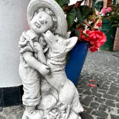 Betongskulptur av en pojke med hund, grå trädgårdsfigur